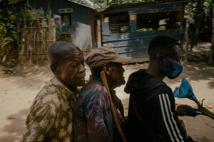 Papa Joseph, squeezed between a motorcycle driver and his brother, sets off for Mbandaka. Photography by Nanna Heitmann