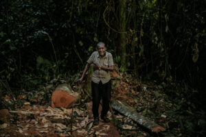 Joseph Bonkile Engobo, known as Papa Joseph, near the stump of a tree he had tried to save.